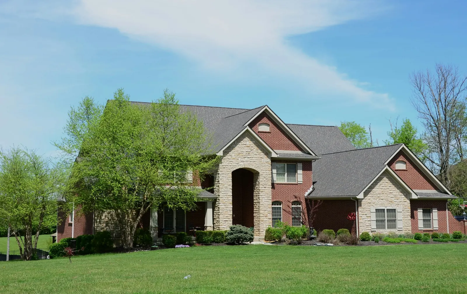 Brick and stone family home with a green lawn in a North Texas neighborhood
